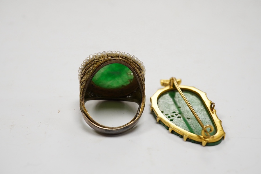 A Chinese yellow metal mounted carved jade leaf brooch, stamped 'TC18', 36mm, gross weight 5.6 grams and a jade and seed pearl set filigree ring. Condition - fair to good